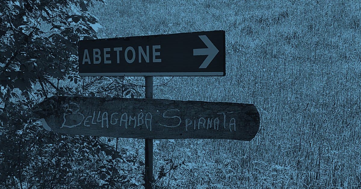 Деревянный и металлический дорожные указатели на фоне горного луга
